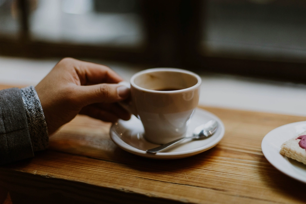 木のテーブルでコーヒーを楽しむ
